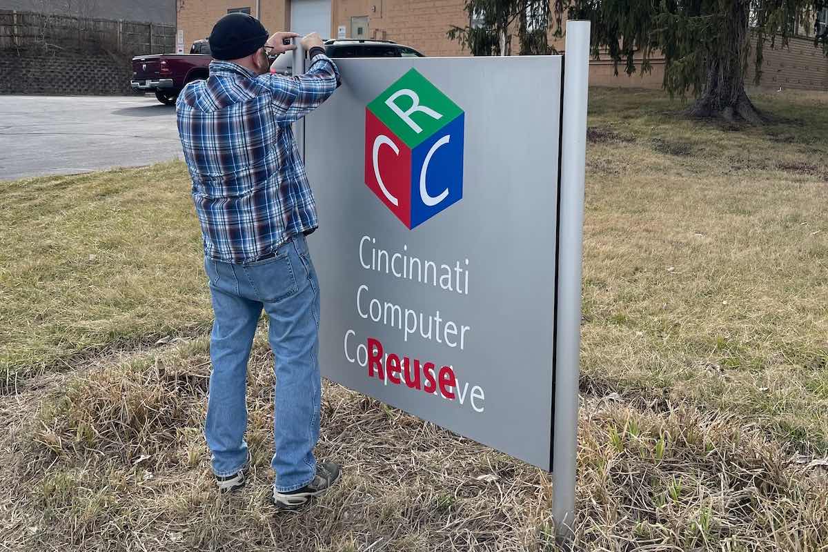 Board member and founder Joe McGuire puts the finishing touches on our revamped sign